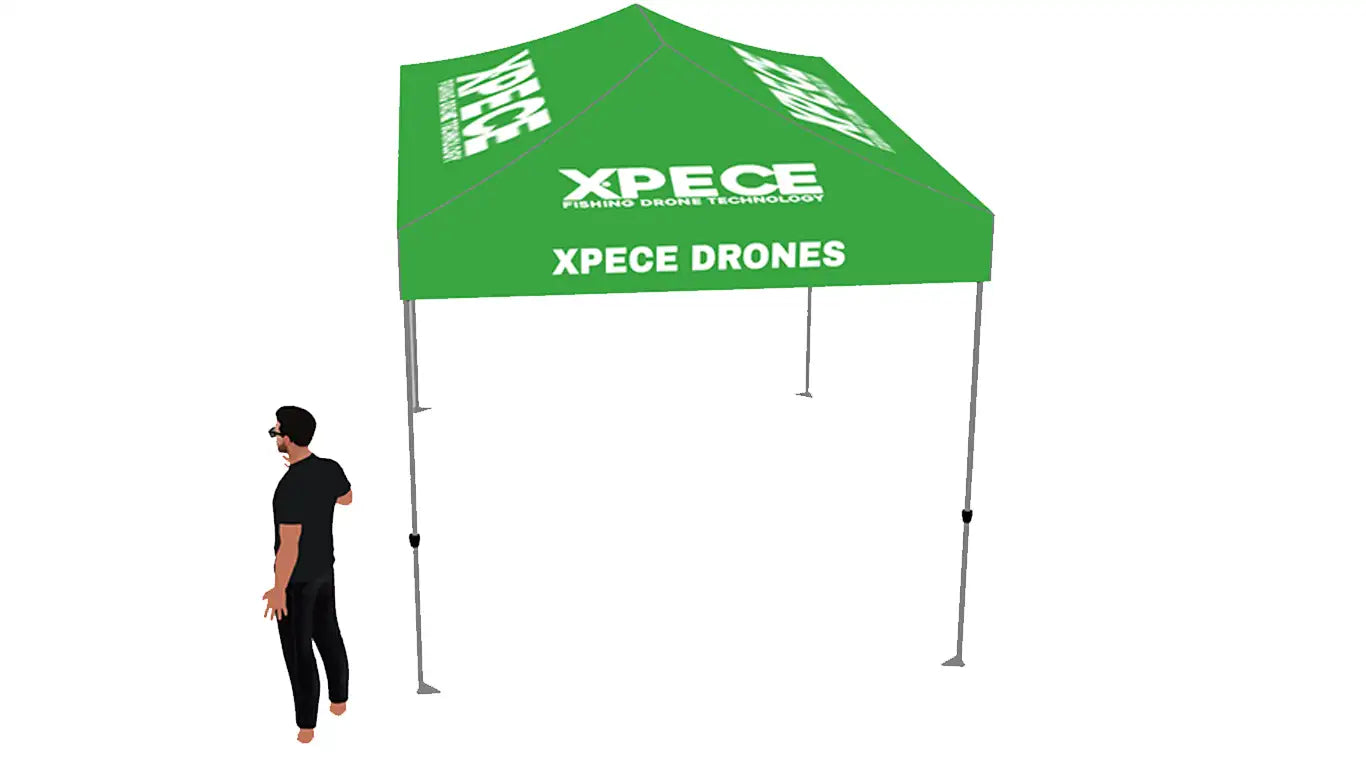 Angled right-side view of green XPECE 10x10 canopy tent showing XPECE.COM and XPECE DRONES branding with person for scale