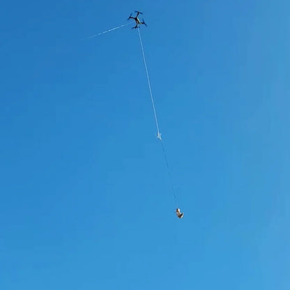 Xpece Rescue Drone flying with a suspended payload on a tether against blue sky